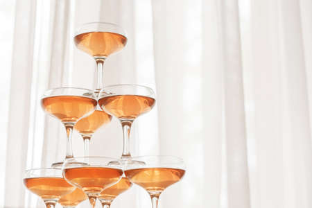 Tower made of glasses with champagne indoorsの写真素材