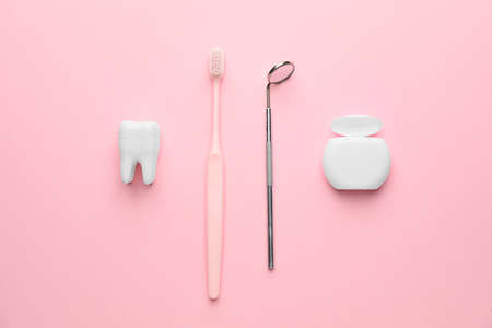 Dental mirror with toothbrush and floss on color backgroundの写真素材