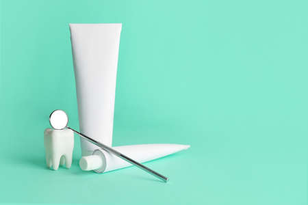 Dental mirror with paste on color background