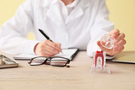 Female dentist working at table, closeup