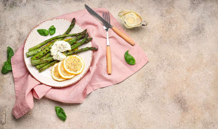 Cooked asparagus with egg and lemon on gray backgroundの写真素材