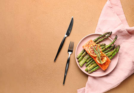 Cooked asparagus with salmon and lemon on color backgroundの写真素材