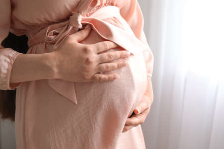 Beautiful pregnant woman at home, closeup