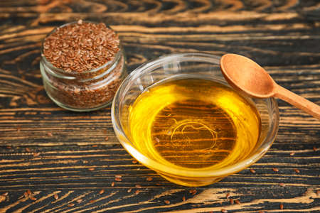 Bowl with flax oil on wooden tableの写真素材