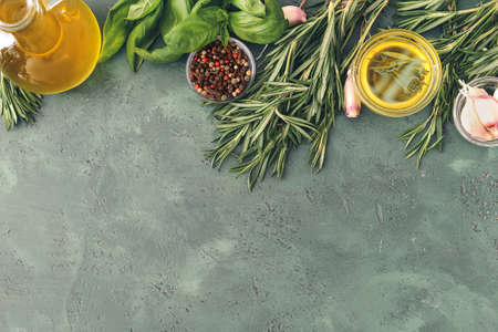 Rosemary oil with spices on color backgroundの写真素材