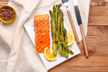 Cooked asparagus with salmon and lemon on tableの写真素材