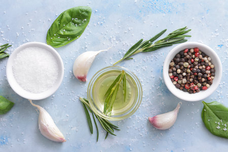 Rosemary oil with spices on color backgroundの写真素材