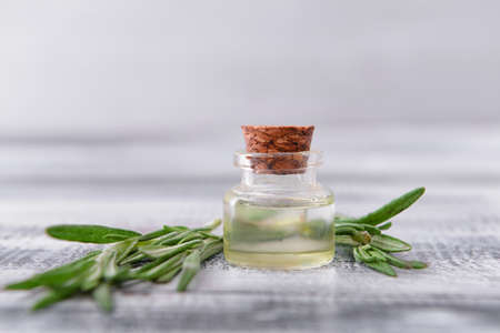 Bottle of rosemary essential oil on table