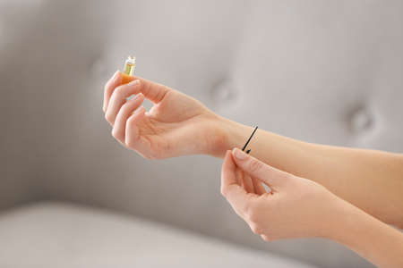 Young woman with perfume sample at homeの写真素材