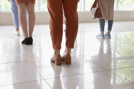 Group of people standing with social distance indoors. Concept of epidemicの写真素材