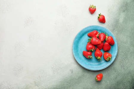 Plate with ripe strawberry on color backgroundの写真素材