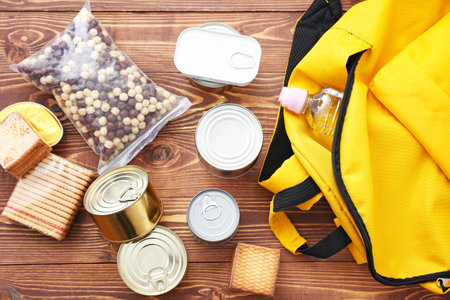 Schoolbag with different products on wooden background. Concept of Backpack Food Program
