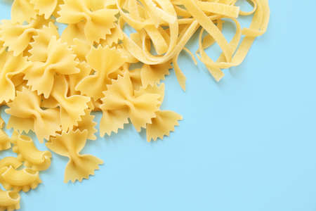 Different uncooked pasta on color backgroundの写真素材