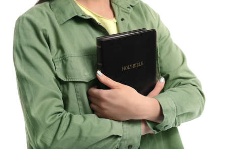 Young woman with Bible on white background, closeup