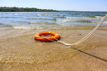 Bright lifebuoy ring on beach