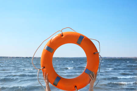 Woman with lifebuoy ring near riverの写真素材