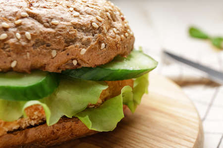 Board with tasty vegan burger on table, closeup