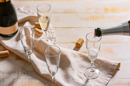 Pouring of champagne in glasses on tableの写真素材