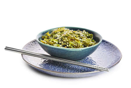 Bowl with tasty seaweed and chopsticks on white backgroundの写真素材