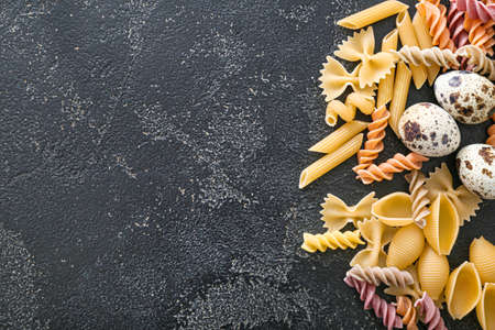 Dry pasta with eggs on dark backgroundの写真素材