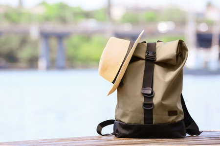 Traveler's backpack and hat near river outdoorsの写真素材