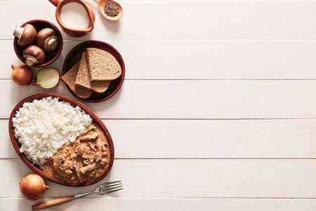 Plate with tasty beef stroganoff and rice on tableの写真素材