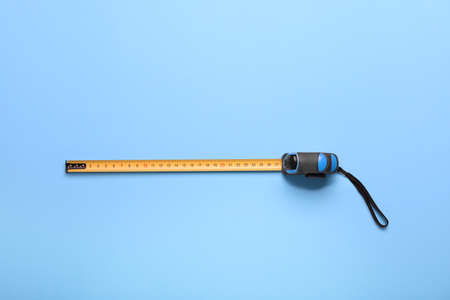 Measuring tape on color background