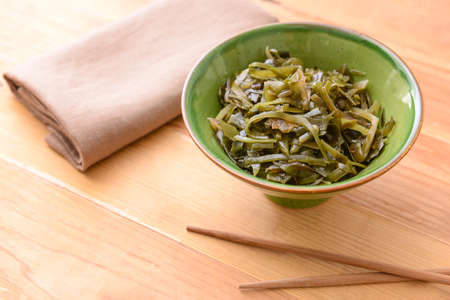 Bowl with tasty seaweed on table