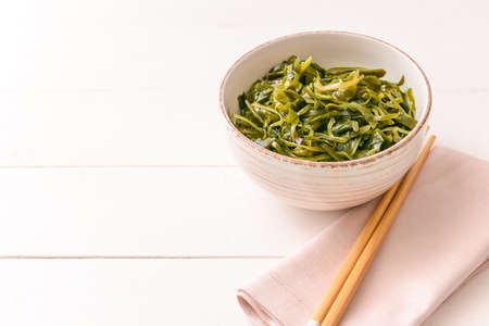 Bowl with tasty seaweed on tableの写真素材