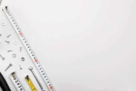 Measuring tapes with builder's supplies on white background