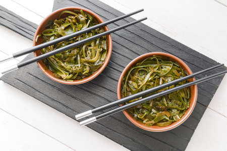 Bowls with tasty seaweed on table