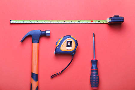 Measuring tapes with builder's supplies on color backgroundの写真素材