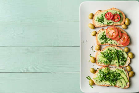 Plate with tasty avocado sandwiches on table