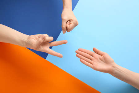 People playing roshambo game on color backgroundの写真素材