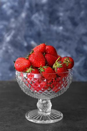 Glass dessert bowl with ripe strawberry on tableの写真素材