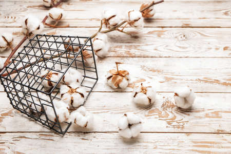 Beautiful cotton flowers and basket on wooden backgroundの写真素材
