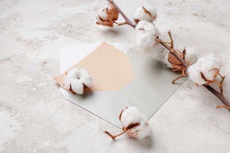 Envelope and beautiful cotton flowers on light backgroundの写真素材
