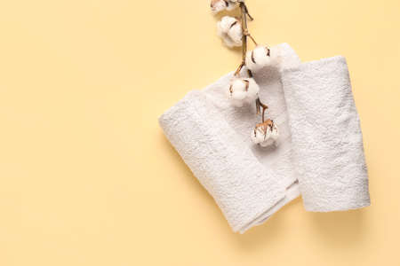Cotton flowers and soft towels on color backgroundの写真素材