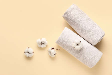 Cotton flowers and soft towels on color backgroundの写真素材