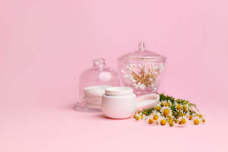 Cosmetic cream with chamomile flowers on color backgroundの写真素材