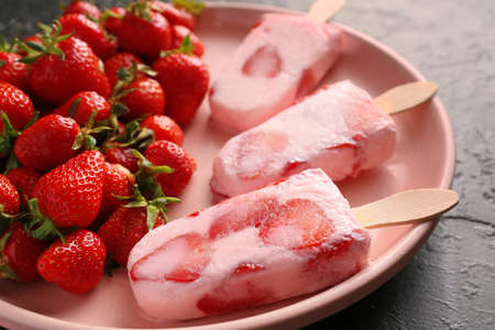 Plate with tasty strawberry ice cream on dark background, closeup