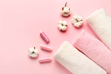 Cotton flowers, threads and soft towels on color backgroundの写真素材