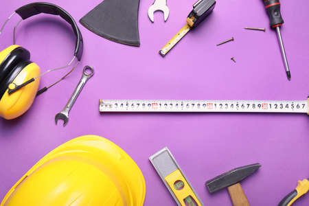 Measuring tape with builder's supplies on color backgroundの写真素材
