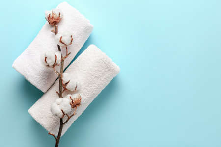 Cotton flowers and soft towels on color backgroundの写真素材