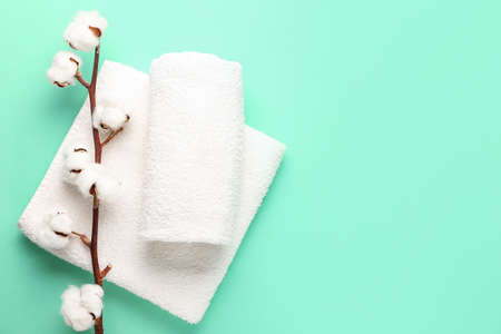 Cotton flowers and soft towels on color backgroundの写真素材
