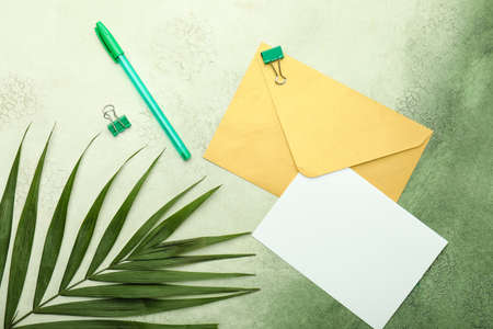Blank card with envelope and stationery on color backgroundの写真素材