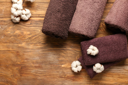 Cotton flowers and soft towels on wooden backgroundの写真素材