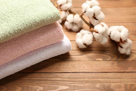Cotton flowers and soft towels on wooden backgroundの写真素材