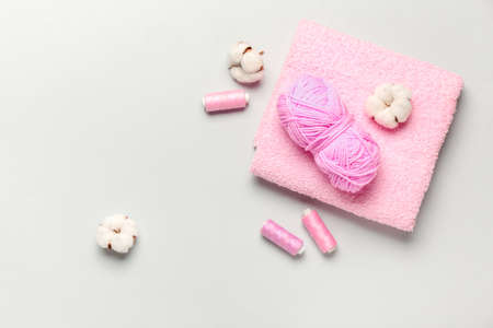 Cotton flowers, threads and soft towel on light backgroundの写真素材