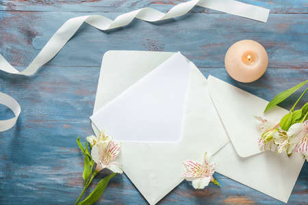 Festive composition with blank card and envelopes on wooden background